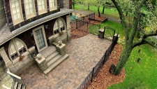Fenced in cobblestone patio and stone stairs to house