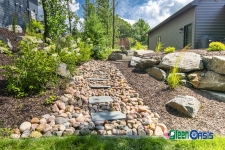 rock creek bed and softscaping on side of house