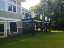 Dark brown second story deck with thick beams and white accents