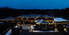 Drone view of huge house at night and trimmed with lights