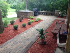 Brick patio with walkway surrounded by red cedar wood chips