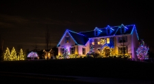Roof trimmed with blue lights and trees with colored lights