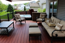 Brownish-red wood deck with surrounding black metal banister